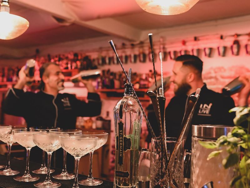 Zwei Barkeeper mixen hinter der Bar Cocktails