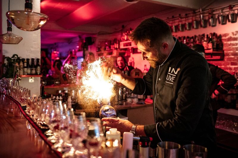 Der Barkeeper liefert eine Feuer-Show bei dem Einschenken im Cocktail-Tasting in der Cocktailschule Frankfurt