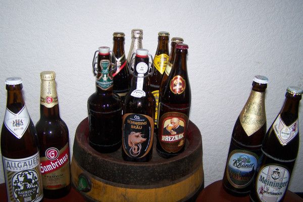Mehrere Bier-Flaschen stehen aufgereiht auf einer Bar