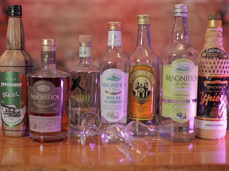 Mehrere Cachaca-Flaschen stehen aufgereiht auf einer Bar
