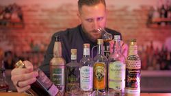 Ein Mann hält eine Flasche Cachaca und lächelt