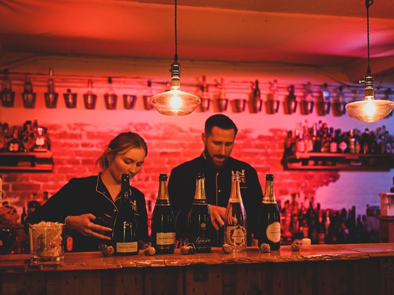Champagner-Flaschen auf der Bar in der IN-LIVE-Cocktailschule Frankfurt