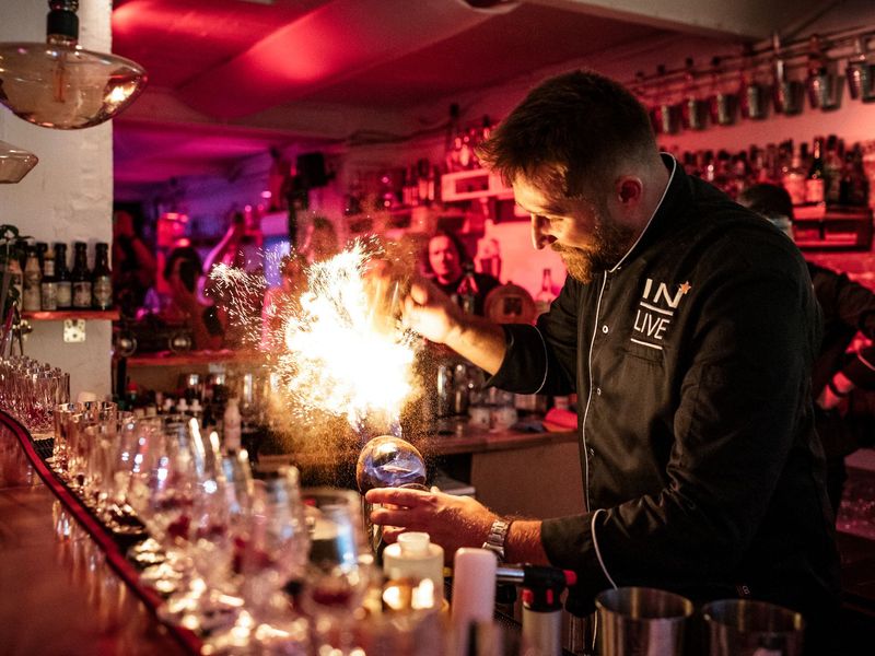 Der Barkeeper liefert eine Feuer-Show bei dem Einschenken im Cocktail-Tasting in der Cocktailschule Frankfurt