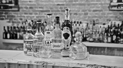 Mehrere Tequila-Flaschen stehen aufgereiht auf einer Bar