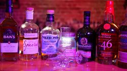 Mehrere Whisky-Flaschen stehen aufgereiht auf einer Bar