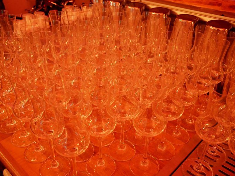 Whisky-Gläser stehen aufgereiht auf einer Bar