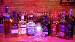 Mehrere Whisky-Flaschen stehen aufgereiht auf einer Bar