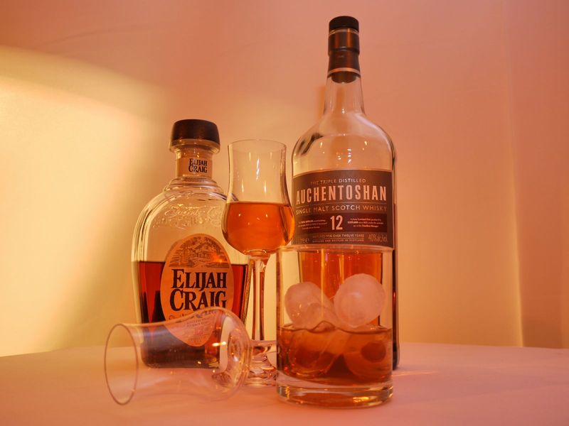 Mehrere Whisky-Flaschen stehen aufgereiht auf einer Bar